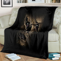 Black mummy face skull blanket, draped across a white-and-cream sofa