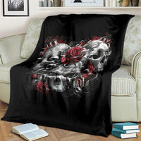 Black skull blanket draped over a couch with red rose and skull artwork