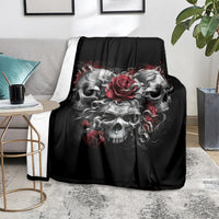 Black skull blanket on a couch, centered gray skulls with red roses