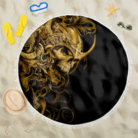 Round beach blanket with golden skull artwork on black fabric and white fringe edge