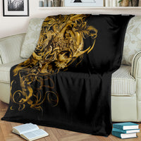 Black skull blanket with gold warrior skull design, draped across couch