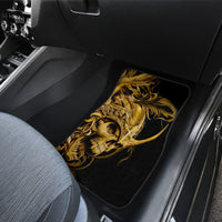 Black car floor mat with golden warrior skull graphic, placed in front seat area