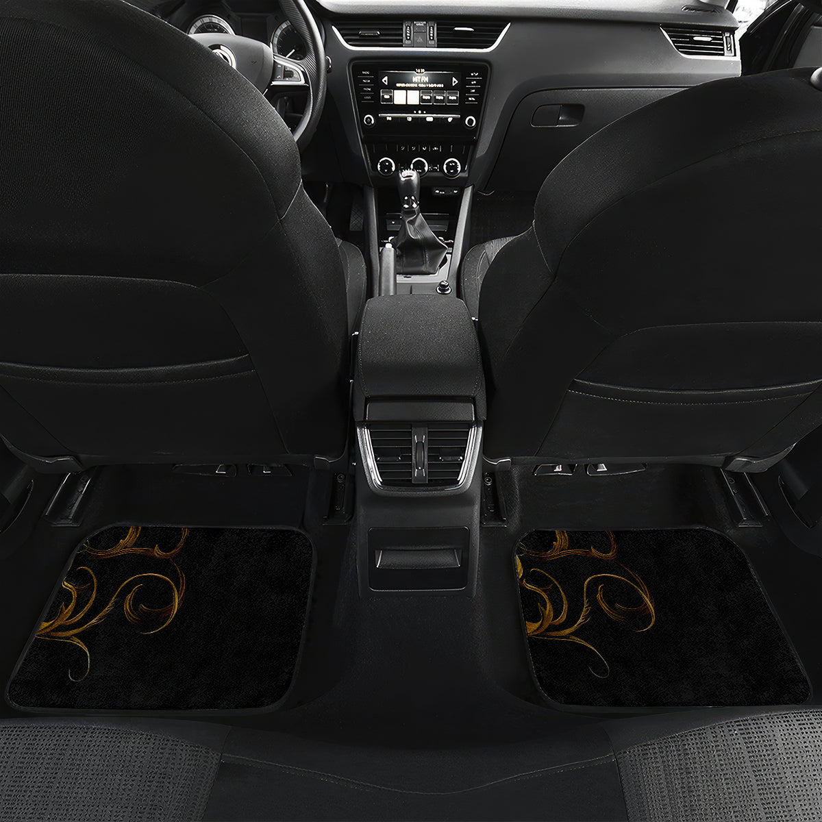 Black car floor mat set with golden swirl accents in the rear footwell
