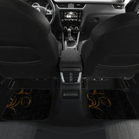 Black car floor mat set with golden swirl accents in the rear footwell