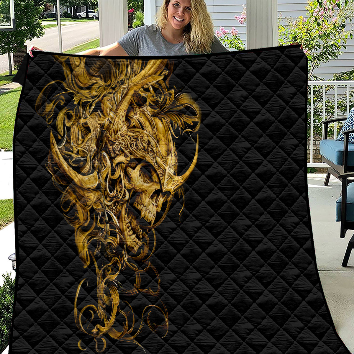 Black quilt with quilted pattern and golden warrior skull graphic on front