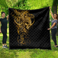 Black quilt with golden warrior skull design, spread out outdoors on grass
