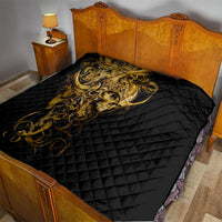 Black quilt on bed with golden warrior skull graphic across the quilted surface