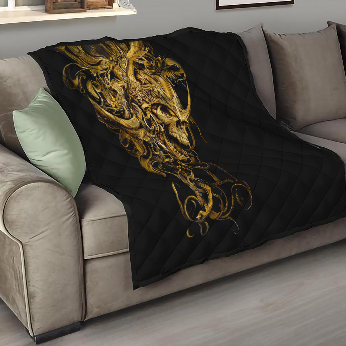 Black quilt draped on sofa with golden warrior skull design