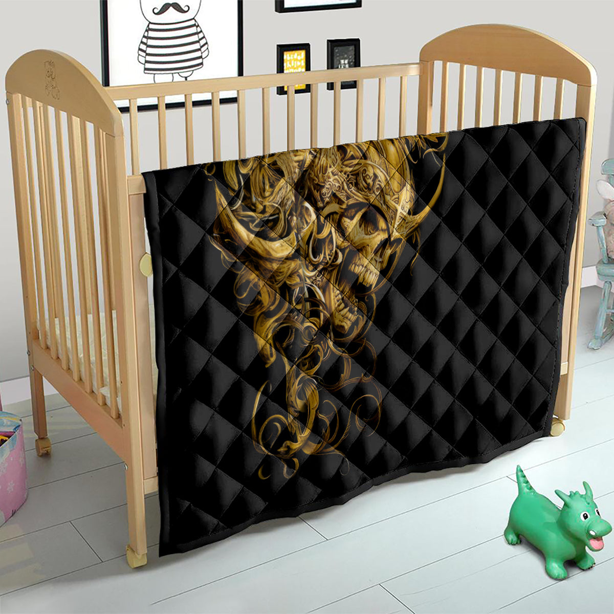Black quilt covering a baby bed with golden warrior skull artwork