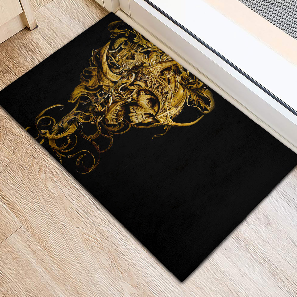Black rubber doormat featuring gold skull warrior design in ornate curls