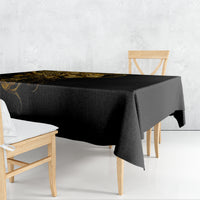 Black tablecloth draped over a dining table, featuring a gold skull-and-warrior print.