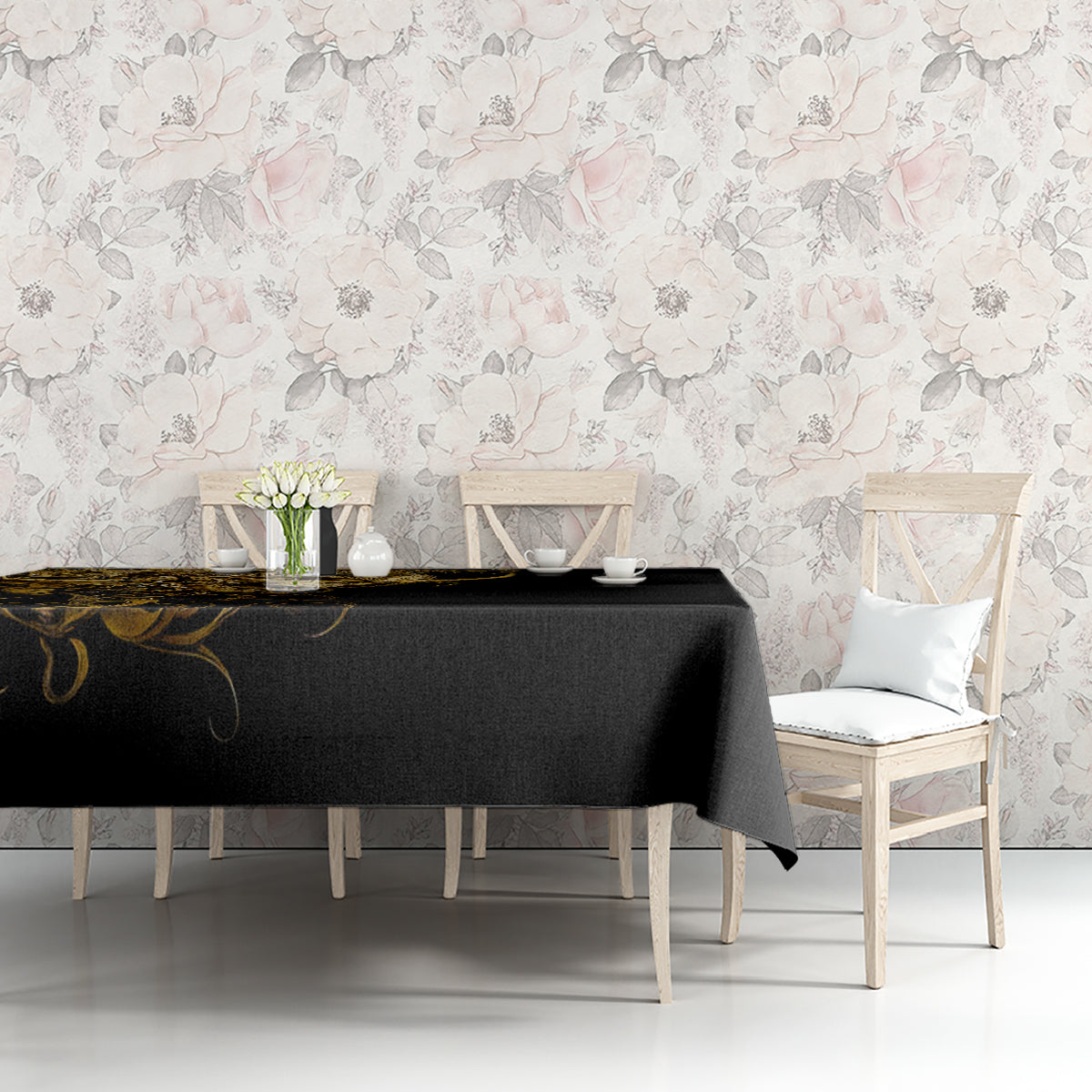 Black tablecloth with gold skull-and-warrior print on a dining table against floral wallpaper.