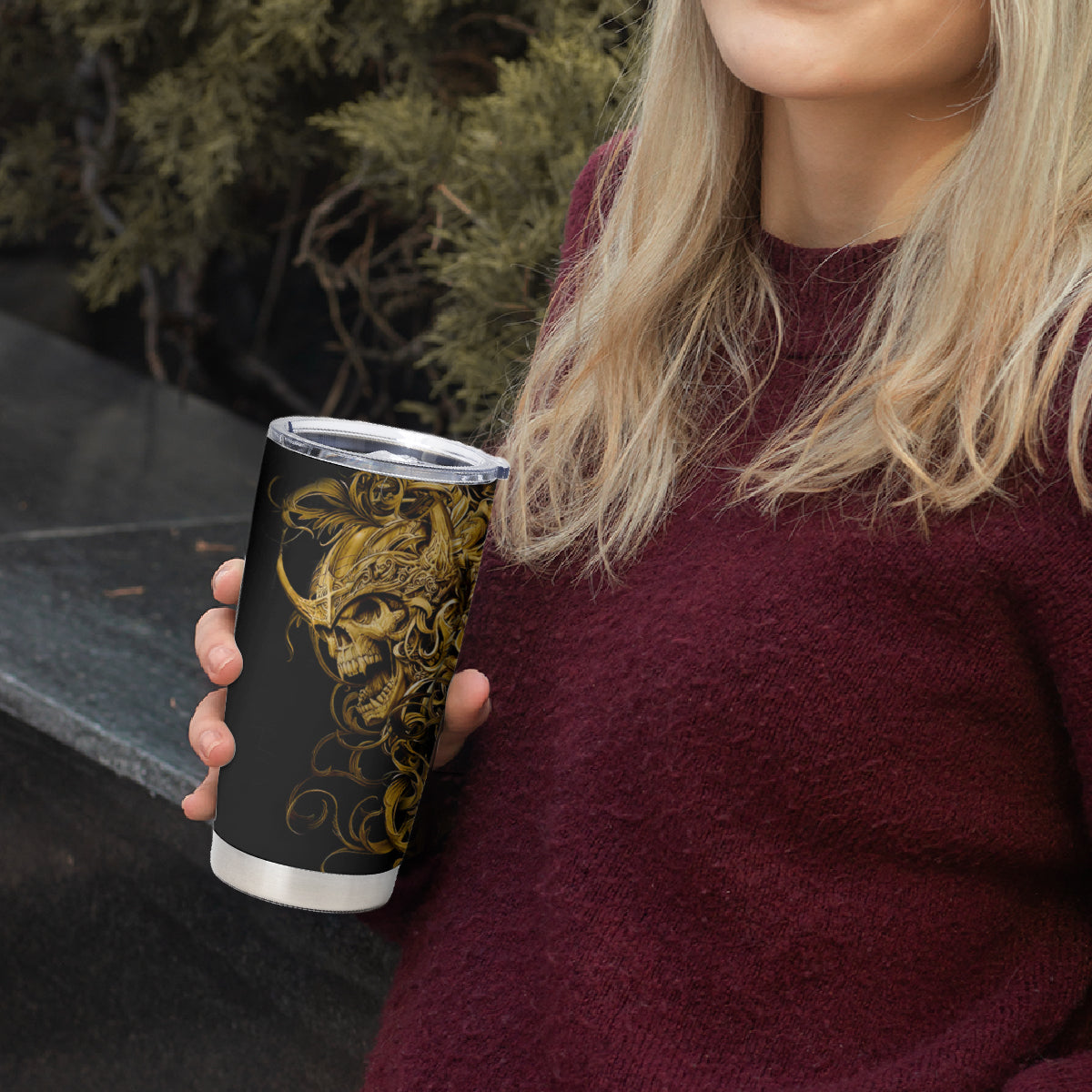 Black tumbler cup with gold skull warrior graphic, clear lid on top.