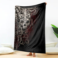 Black skull blanket with silver ornate skull graphic and red flame accents, draped view