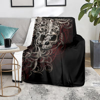 Black skull blanket with silver skull artwork and red flames, covering sofa