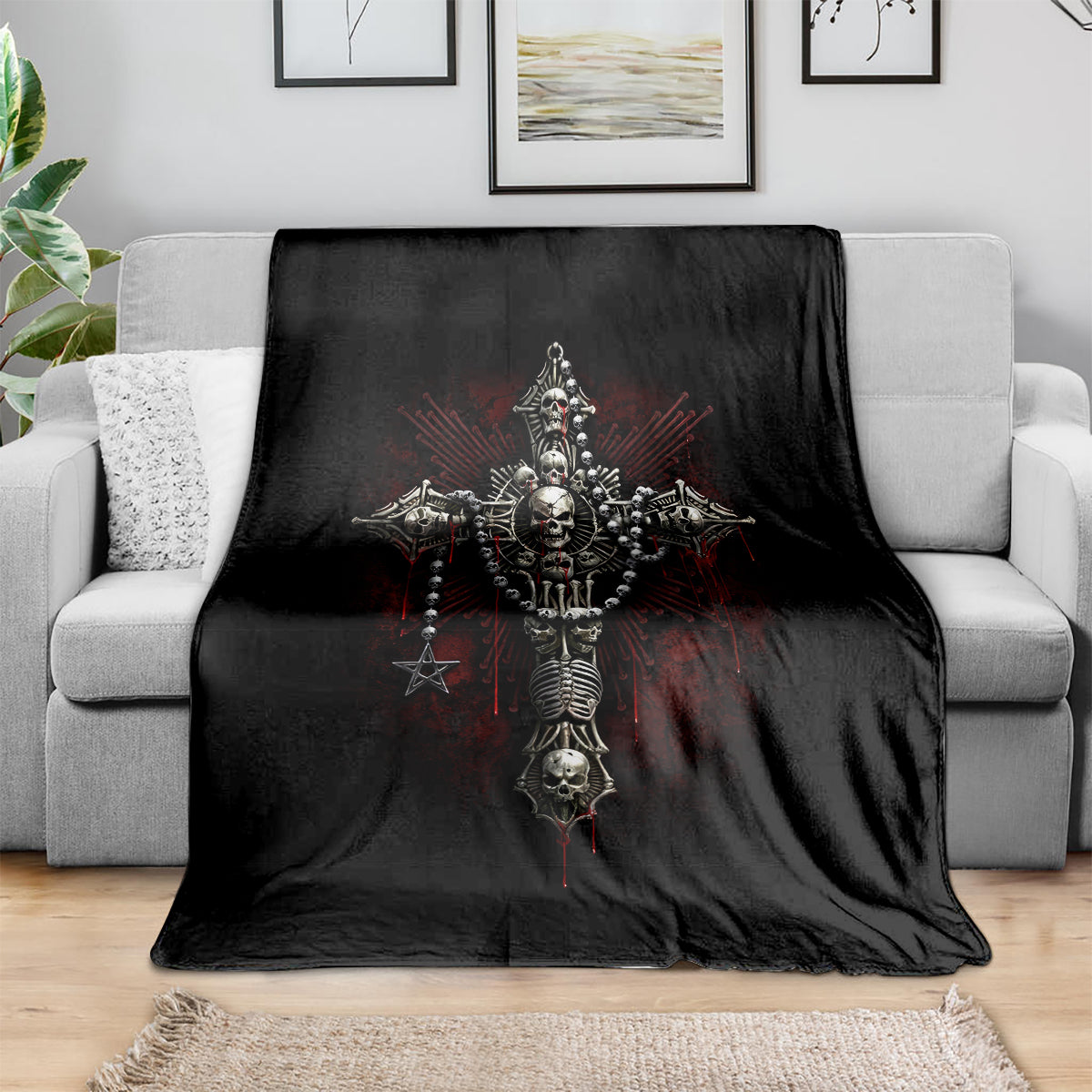 Black skull cross blanket draped over gray sofa, featuring ornate skeletal artwork