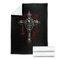 Black skull cross blanket with red burst accents, folded beside white towels