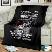 Black skull throw blanket draped on sofa, with “Spoiled Wife” text and skeleton art