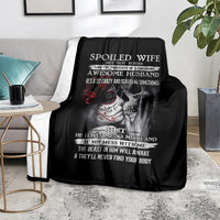 Black skull throw blanket spread on couch with “Spoiled Wife” skeleton graphic
