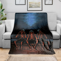 Black skeleton throw blanket draped over sofa with three orange skeletons