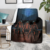 Black skeleton skull throw blanket, three orange skeletons draped on couch