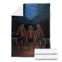 Black skeleton skull throw blanket with three orange skeletons, folded with white towels