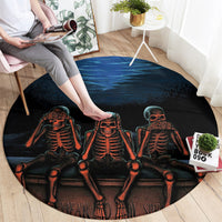 Black round carpet with three orange skeleton figures and partial "hear" and "speak" text