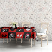 Red skeleton Christmas tablecloth stretched on table with skull, tree, and snowflake prints