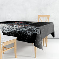 Black patterned tablecloth draped over dining table with winter skeleton Santa design