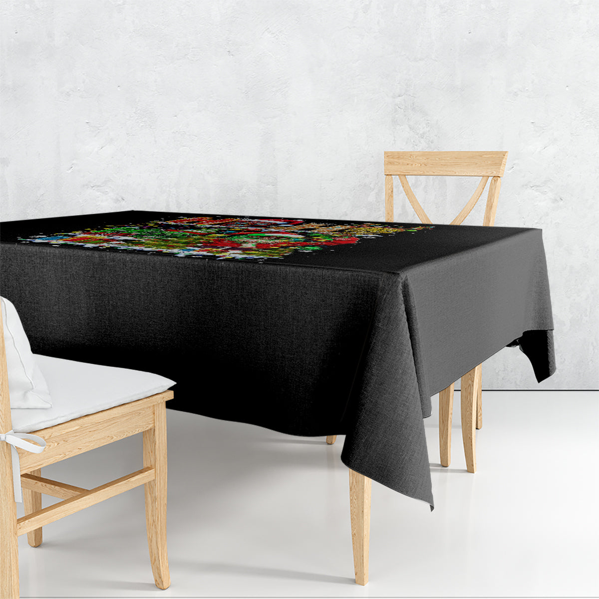 Black festive tablecloth draped over a square table with colorful holiday print.
