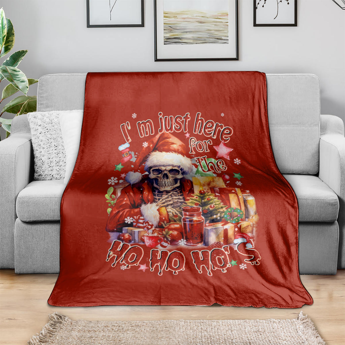 Red Christmas blanket with skeleton Santa and 'Ho Ho Ho' design, spread on sofa