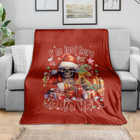 Red Christmas blanket with skeleton Santa and 'Ho Ho Ho' design, spread on sofa