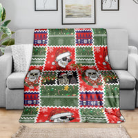 Skeleton Santa blanket spread on sofa, red and green Christmas sweater print with skulls