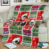 Skeleton Santa blanket draped on couch, red-green Christmas sweater print with skull faces