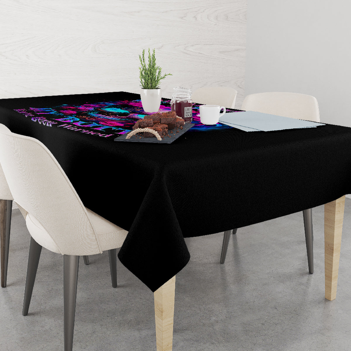 Black tablecloth with colorful sugar skull print along the table’s corner and surface