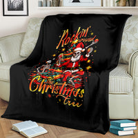 Black throw blanket on a couch, skeleton Santa and Christmas tree 'Rockin' Around' art.