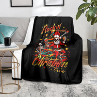 Black throw blanket on a living room rug with skeleton Santa 'Rockin' Around' graphic.