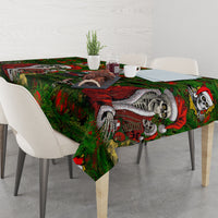 Green tablecloth with skeleton Santa artwork and candy-cane accents across the tabletop