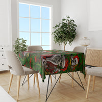 Green skeleton Santa tablecloth on dining table, red and gray skeleton figures repeating