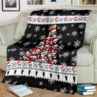 Black holiday throw blanket featuring skull Santa tree center, snowflakes, and stripe hem border