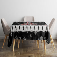 Black Christmas tablecloth covering square table with jagged snowflake and arrow borders