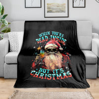 Black Christmas throw blanket with skeleton Santa graphic and quote text on gray sofa