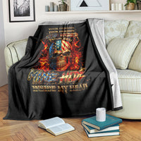 Black fire skull blanket draped on couch with flaming skull graphic and gold text