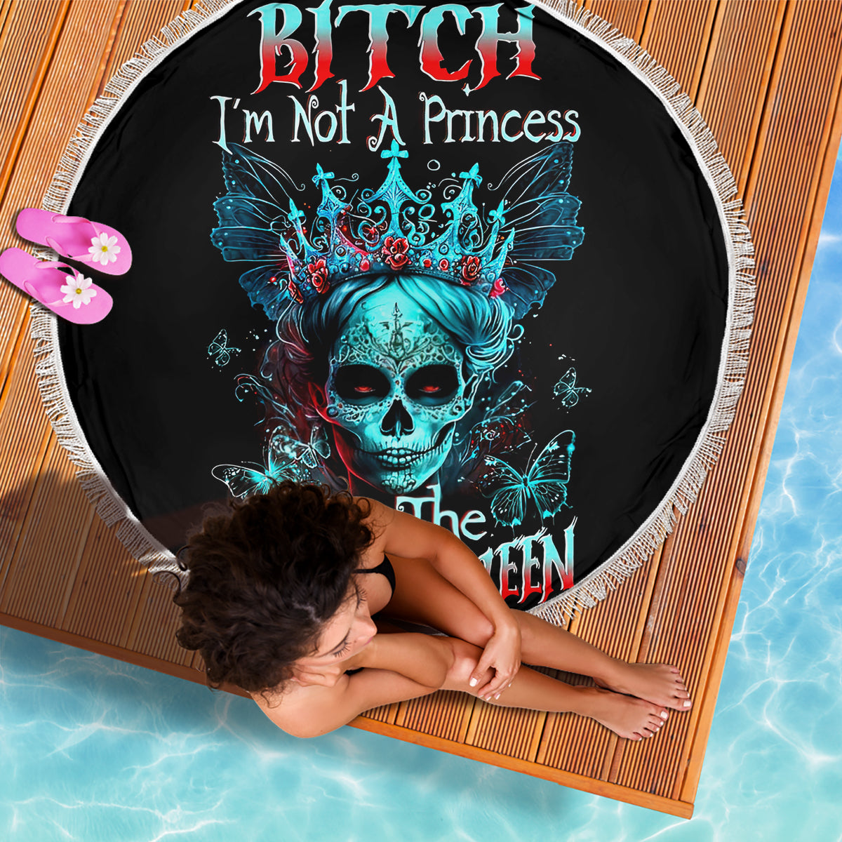 Round black beach blanket with teal skull crown, butterflies graphic, white fringe border