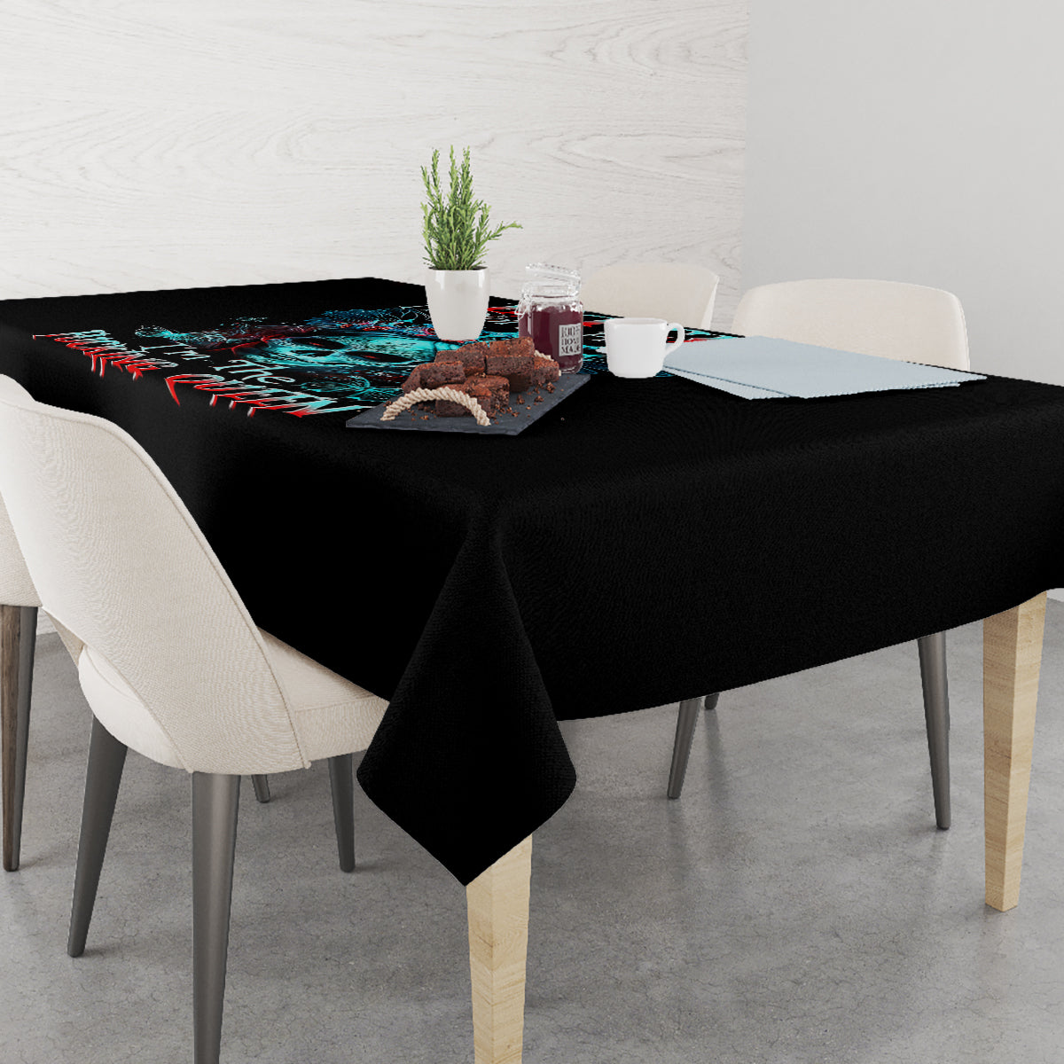 Black skull tablecloth on rectangular table with blue skull artwork and hanging corner