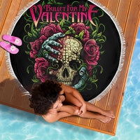 Black round beach blanket with fringed edge, skull and roses graphic in view