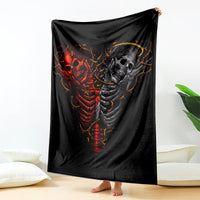 Black throw blanket with red-and-gray skull skeleton graphic, draped over furniture