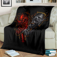 Black throw blanket with red and gray skull skeleton graphic, laid on a sofa