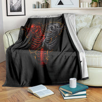 Black skull skeleton blanket with red-and-gray graphic, draped over a couch back