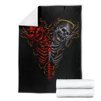 Black skull skeleton blanket with red and gray graphic, shown folded with rolled stacks